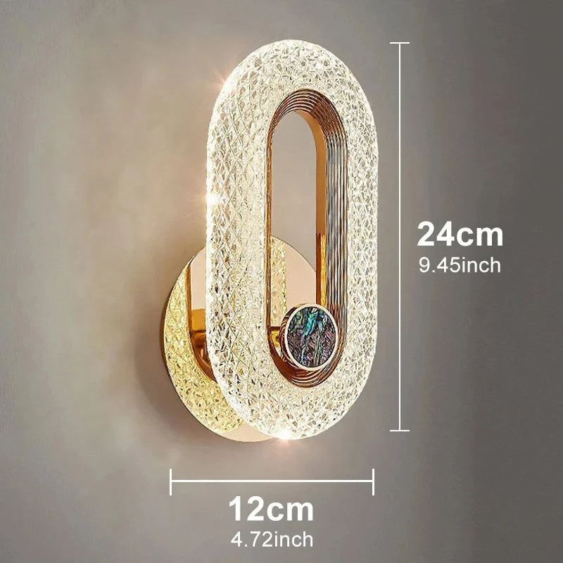 arandela de cristal led oval dourada acesa na parede - foto 6