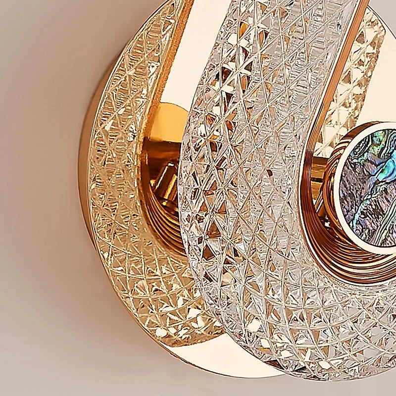 arandela de cristal led oval dourada acesa na parede - foto 2