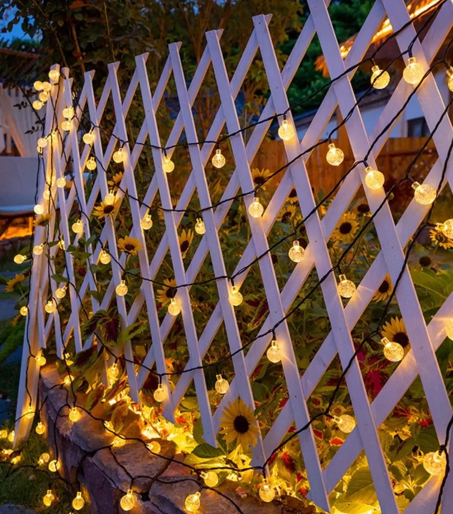 cordão solar de bolinhas de luz led branco quente aceso em jardim - foto 2