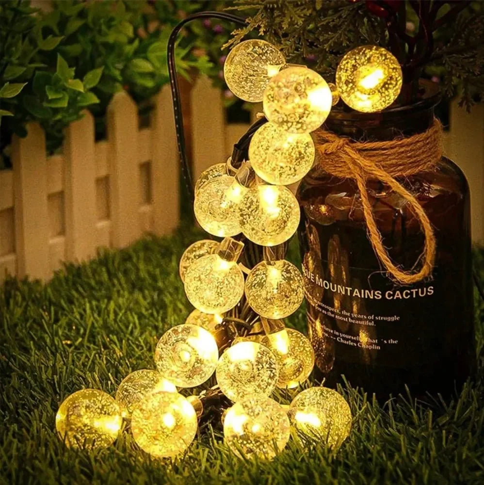 cordão solar de bolinhas de luz led branco quente aceso em jardim - foto 3