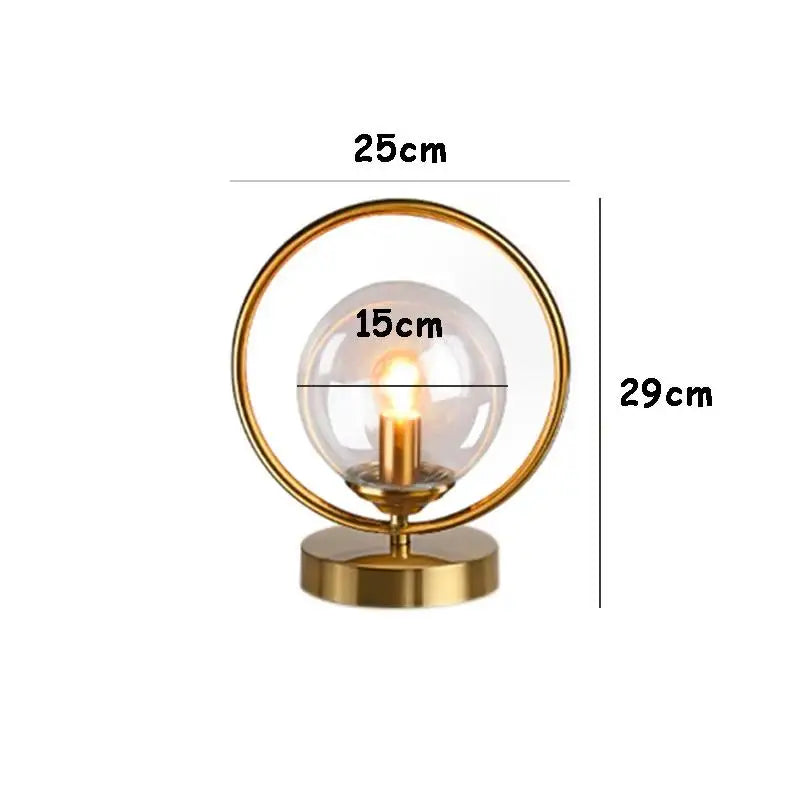 luminária de mesa com esfera de vidro âmbar e anel dourado acesa - foto 4